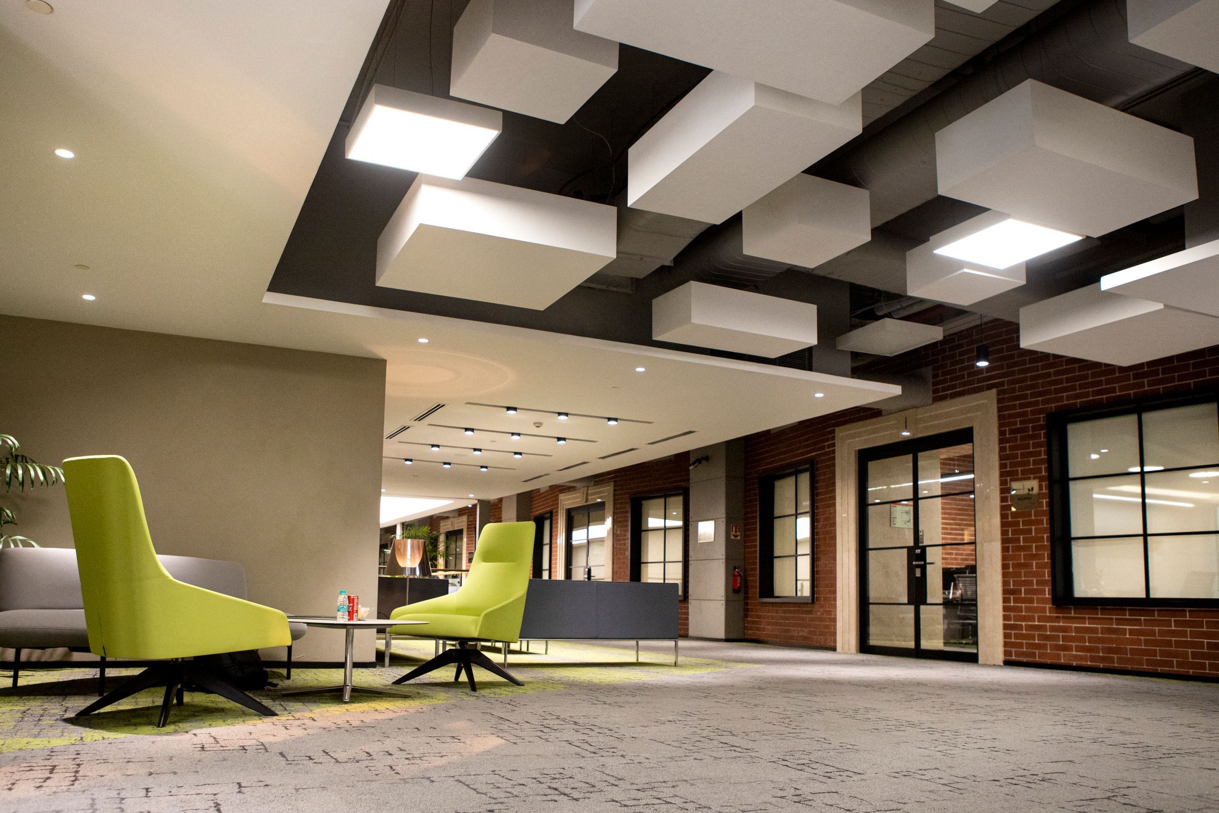 Plateau de bureaux avec îlots de plafond suspendus, cloisons vitrées et espace d’accueil