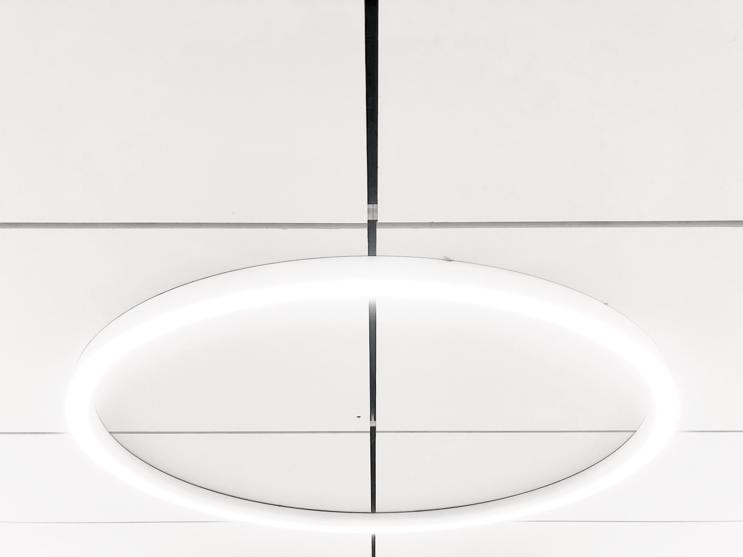 Luminaire circulaire encastré dans un plafond suspendu blanc