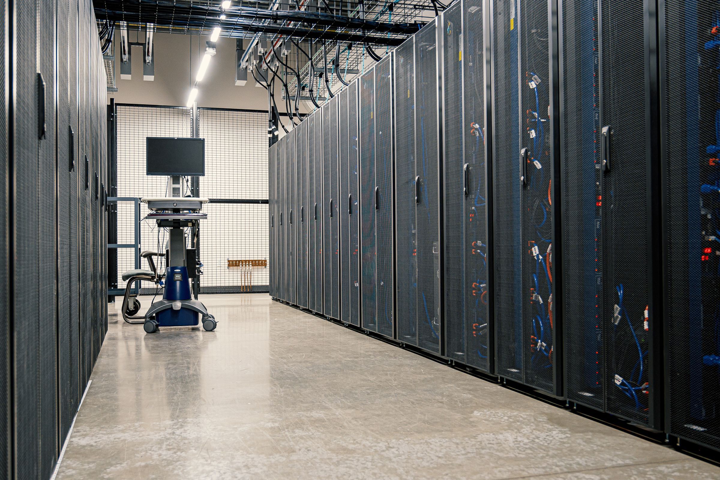 Salle serveurs sur plancher technique, baies informatiques alignées